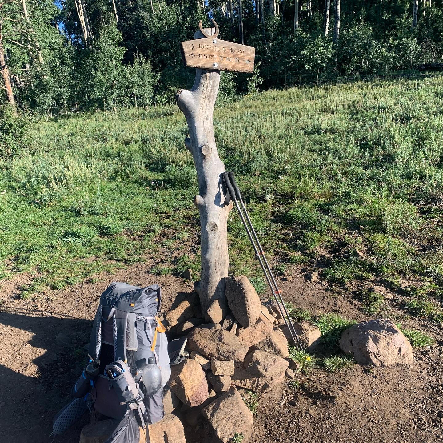 Backpack at a trail crossing A lightweight backpack propped up on rocks at a trail intersection in the Rocky Mountains