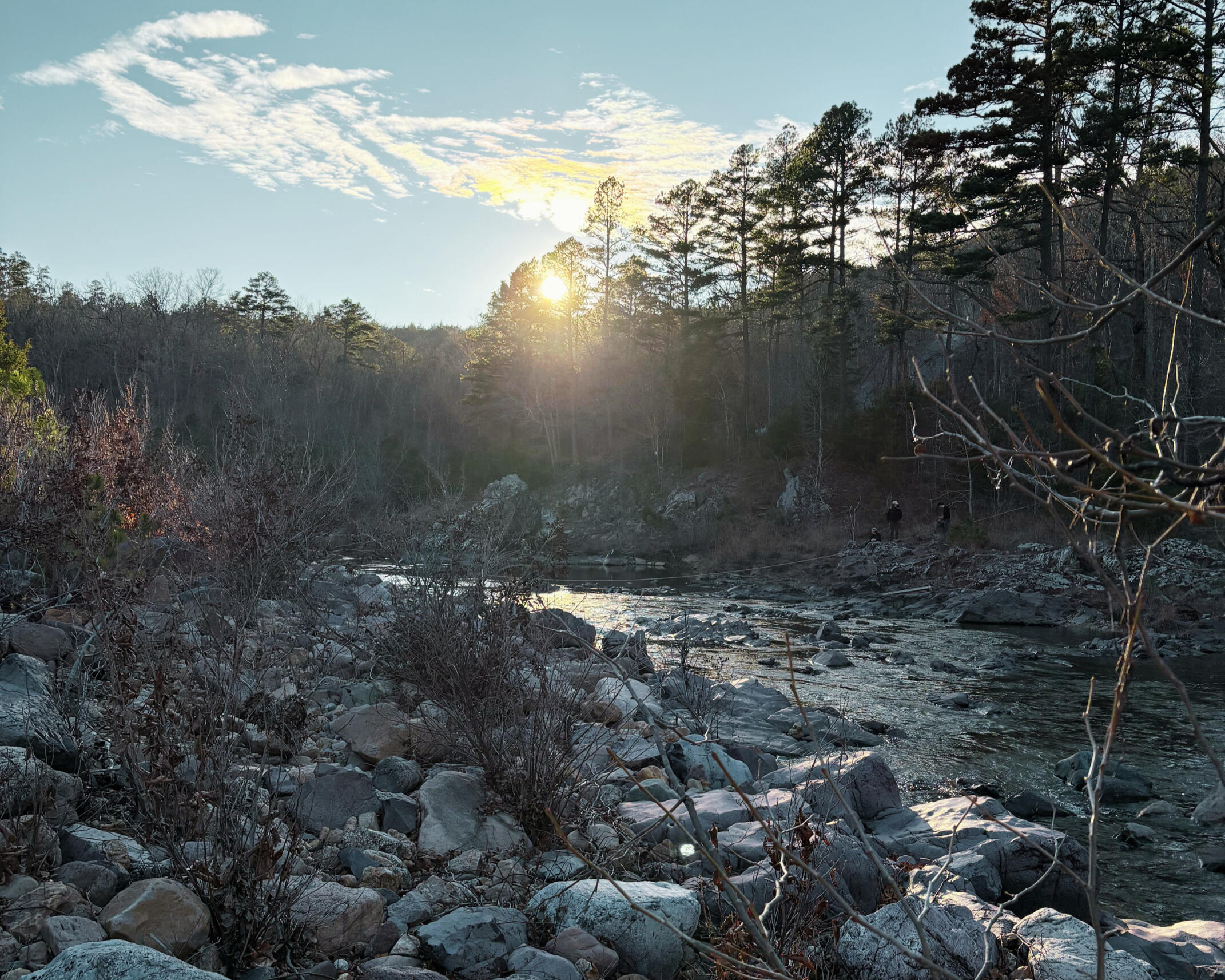 Sunset over the river in the ozarks Sunset over the river in the Ozarks with the sun peaking through the pines.