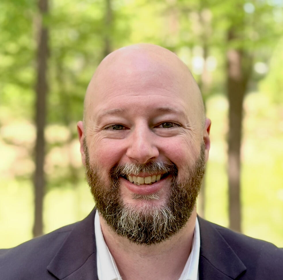 Shayne Martin Shayne Martin with trees in the background, beard and bald, and middle aged with the look of experience.